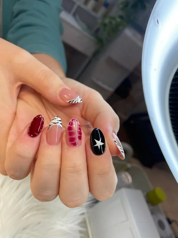Uñas almendradas con un diseño distinto en cada uña: cebra, cuadros y estrella