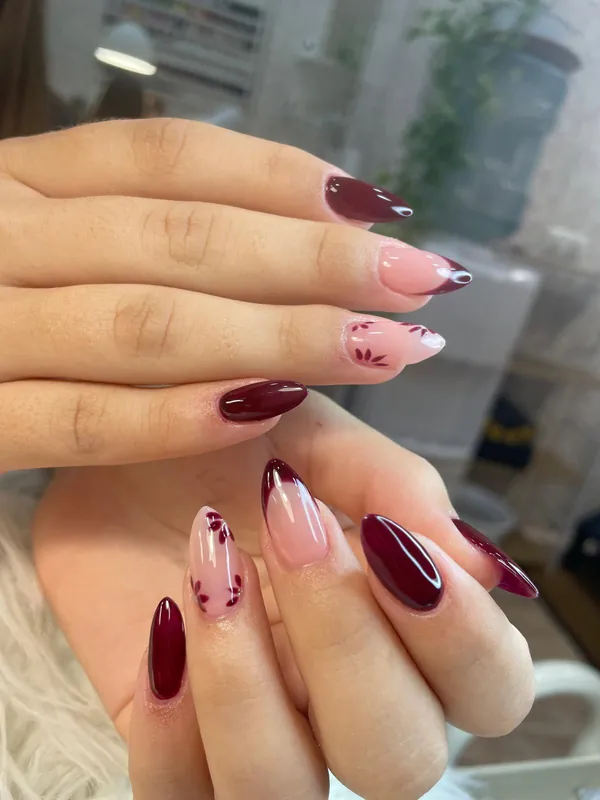 Uñas almendradas en burdeos y nude con detalles de hojas, recién hechas en el estudio